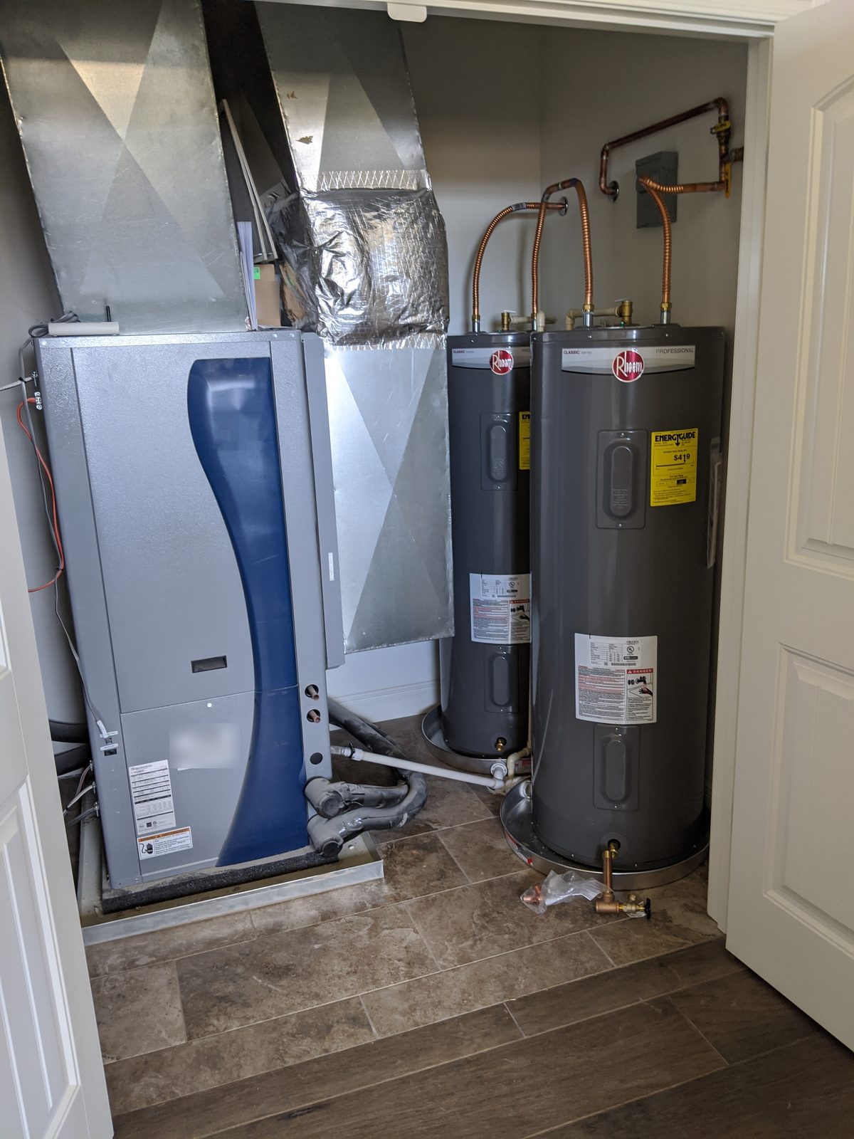 Geothermal heat pump installed in a mechanical closet beside two water heaters, new construction home near Paragould