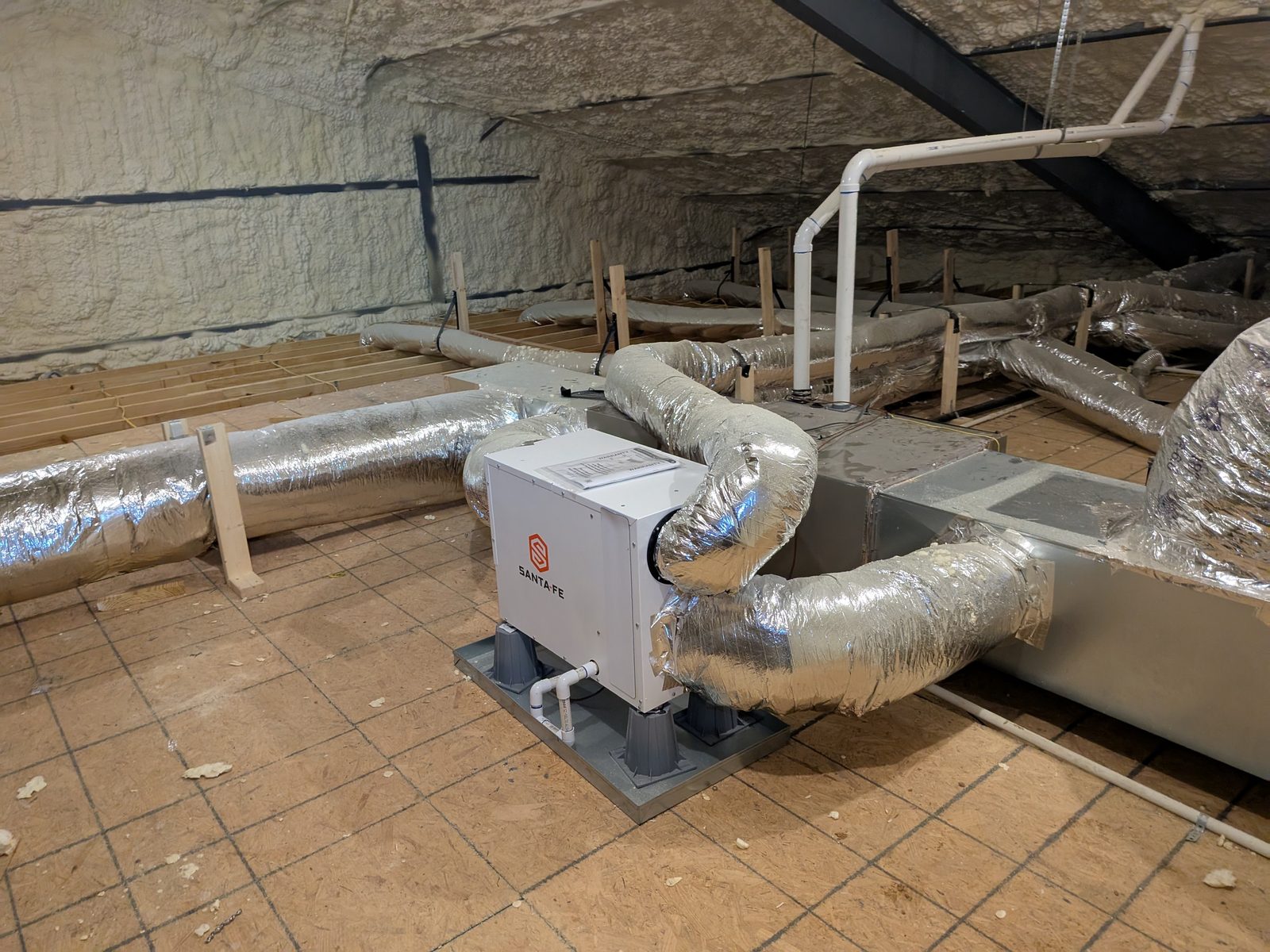 Santa Fe whole-house dehumidifier connected into the duct system in an attic